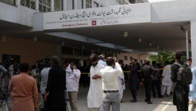 تجمع صحفيون خارج المستشفى الذي تعرض للحريق، يظهر في الصورة الملتقطة نهاراً جانب من مبنى المستشفى وأمامه صحفيون وعدسات الكاميرات.
