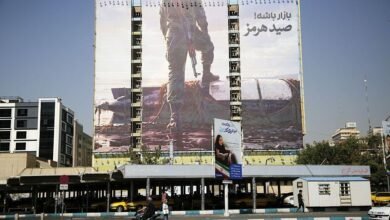 لوحة إعلانية ضخمة تُظهر عنصراً مسلحاً من الحرس الثوري الإيراني يقف واضعاً إحدى قدميه على مركبة "ريموس 600" الأمريكية -وهي مركبة ذاتية القيادة تحت الماء- في ساحة "فاناك" بوسط طهران، إيران، بتاريخ 28 سبتمبر/أيلول 2026.
