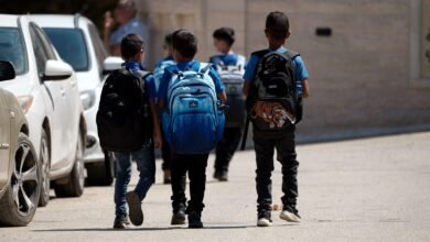 Palestinian kids walk to school. They are wearing blue school uniforms.