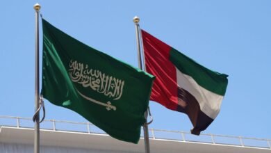 أعلام المملكة العربية السعودية والإمارات العربية المتحدة ترفرف على سارية العلم في السماء. الدول الأكثر تأثيراً في الخليج العربي.