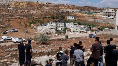 فلسطينيون يتفقدون الأضرار بعد أن هدمت القوات الإسرائيلية مبنى سكنيا من طابقين مملوكا لفلسطينيين في بلدة قلنديا، شمال غربي القدس الشرقية.