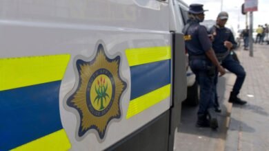 صورة أرشيفية لعناصر من شرطة جنوب أفريقيا (SAPS) يقفون قرب سيارة شرطة في جوهانسبرغ