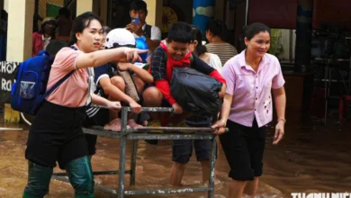 Giáo viên đẩy xe đưa học sinh qua vùng ngập