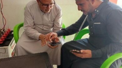 في قرية "النور للمكفوفين بسوريا"... كيف يرى فاقدو البصر بالذكاء الاصطناعي؟ 3 رجلان يجلسان بجوار بعضهما ويمسكان بهاتفين ذكيين.