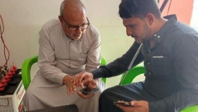 رجلان يجلسان بجوار بعضهما ويمسكان بهاتفين ذكيين.