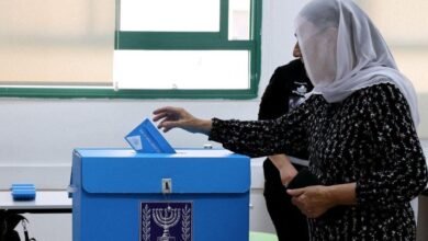 امرأة ترتدي غطاءً للرأس (حجاب) تضع ورقة اقتراع في صندوق الاقتراع خلال الانتخابات العامة في إسرائيل (27/10/2026).